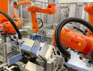 RUF automatizovani robotski sistem za pakovanje sa više narandžastih industrijskih robota i hvataljki.